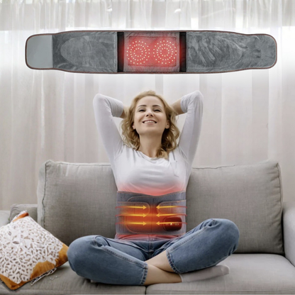 Woman sitting on a couch with an infrared massage and heating belt on her lap, showing glowing red and orange lights.
